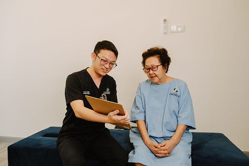 A chiropractor talking a patient through her assessment