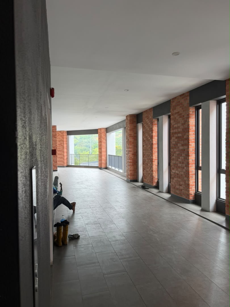 1st-floor brick corridor, with an arrow turning left at the end towards the clinic