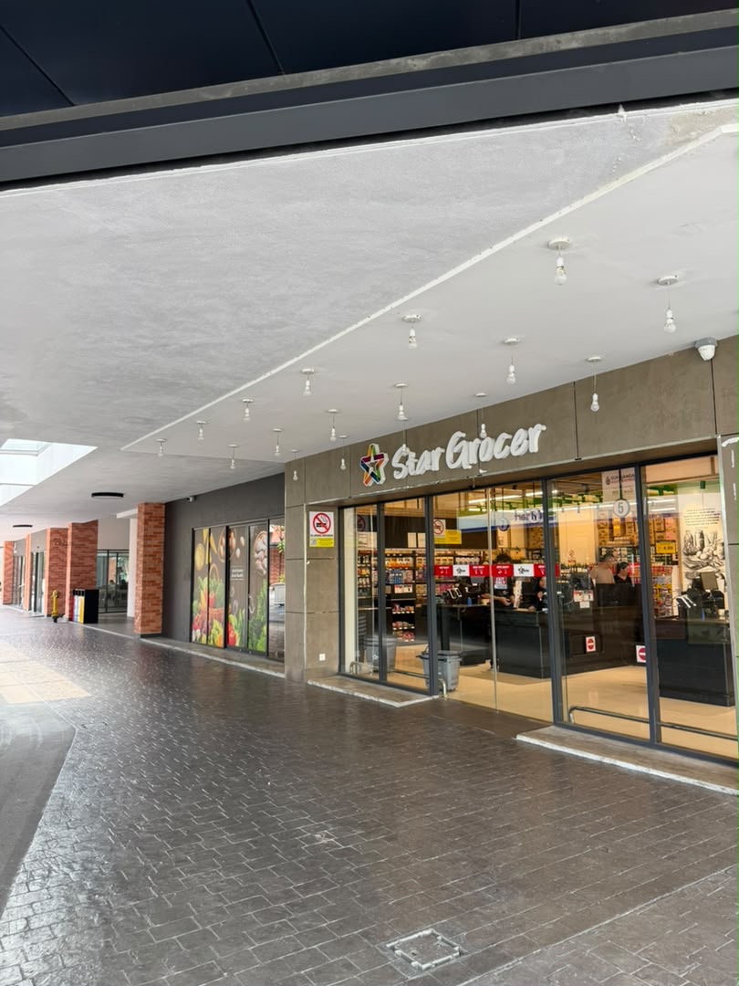 Walkway outside Star Grocer, with an arrow pointing along the corridor towards the lift